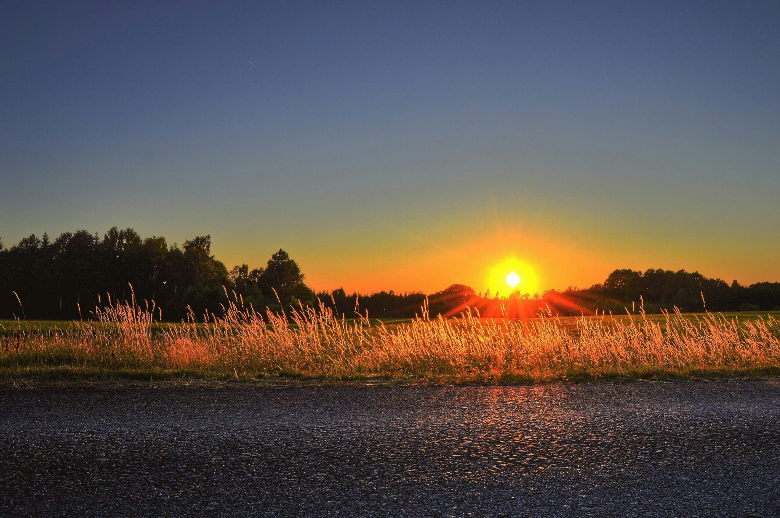 A breathtaking sunrise over a serene Swedish countryside with vibrant sky reflections.